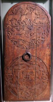 Porte en bois sculpté ornée de scènes chevaleresques et d'entrelacs zoomorphes.