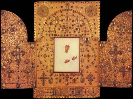 Triptyque-reliquaire en or orné de filigranes, pierres précieuses, émaux et icônes, avec panneau central peint.