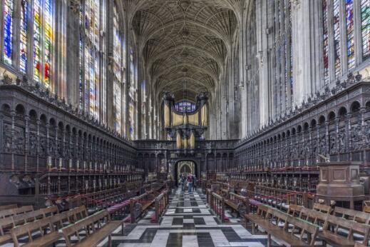 Chœur de chapelle gothique avec stalles sculptées, voûtes en éventail, orgue et vitraux.