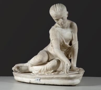 Statue en marbre représentant une jeune femme assise dans une attitude de jeu.