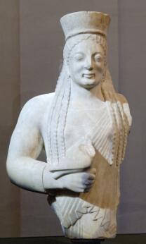 Statue en marbre représentant une korè drapée tenant une offrande.