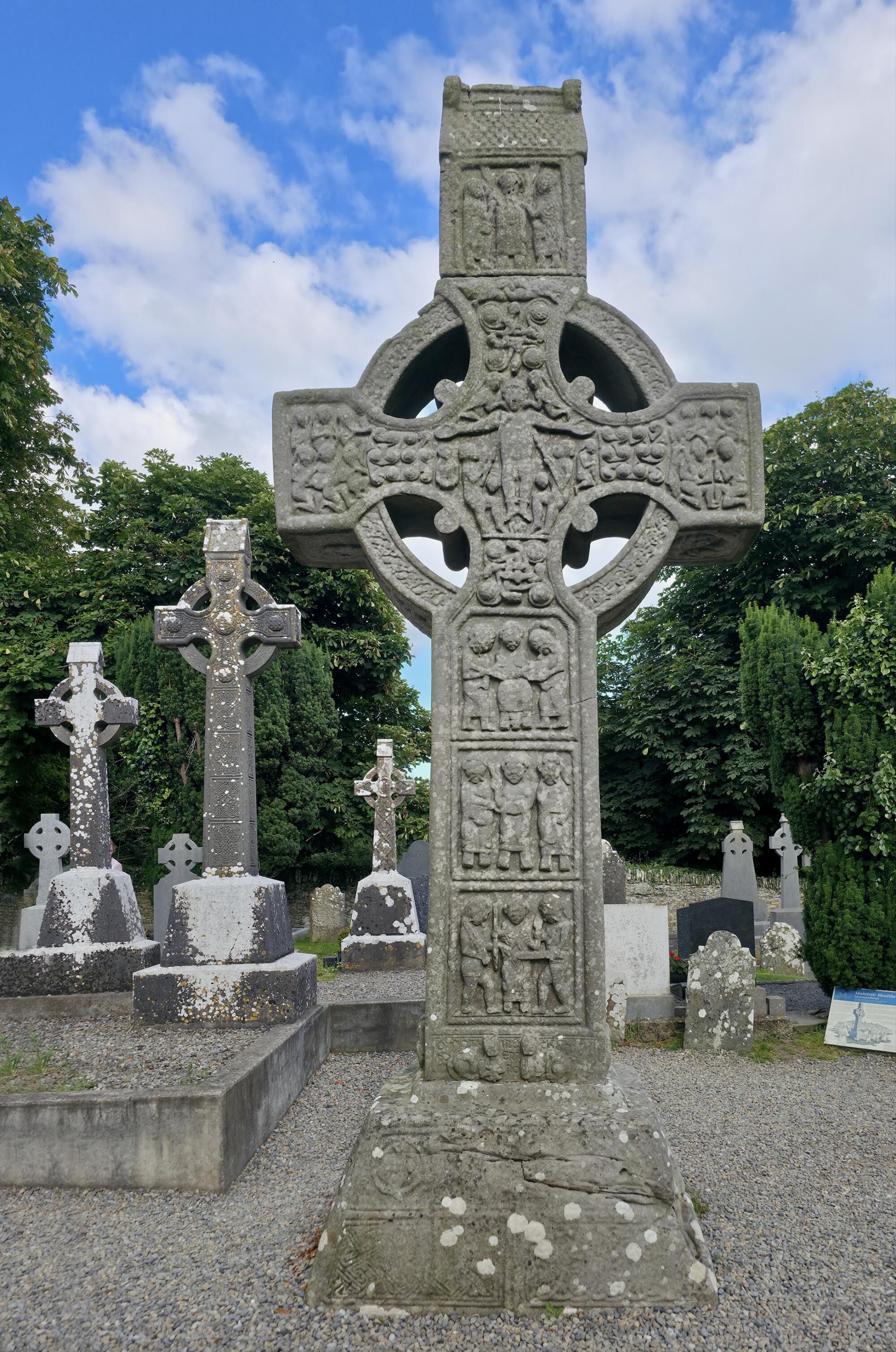 Preview of: Muiredach's High Cross Haute croix celtique en pierre sculptée de scènes bibliques et de motifs entrelacés, dressée dans un cimetière.