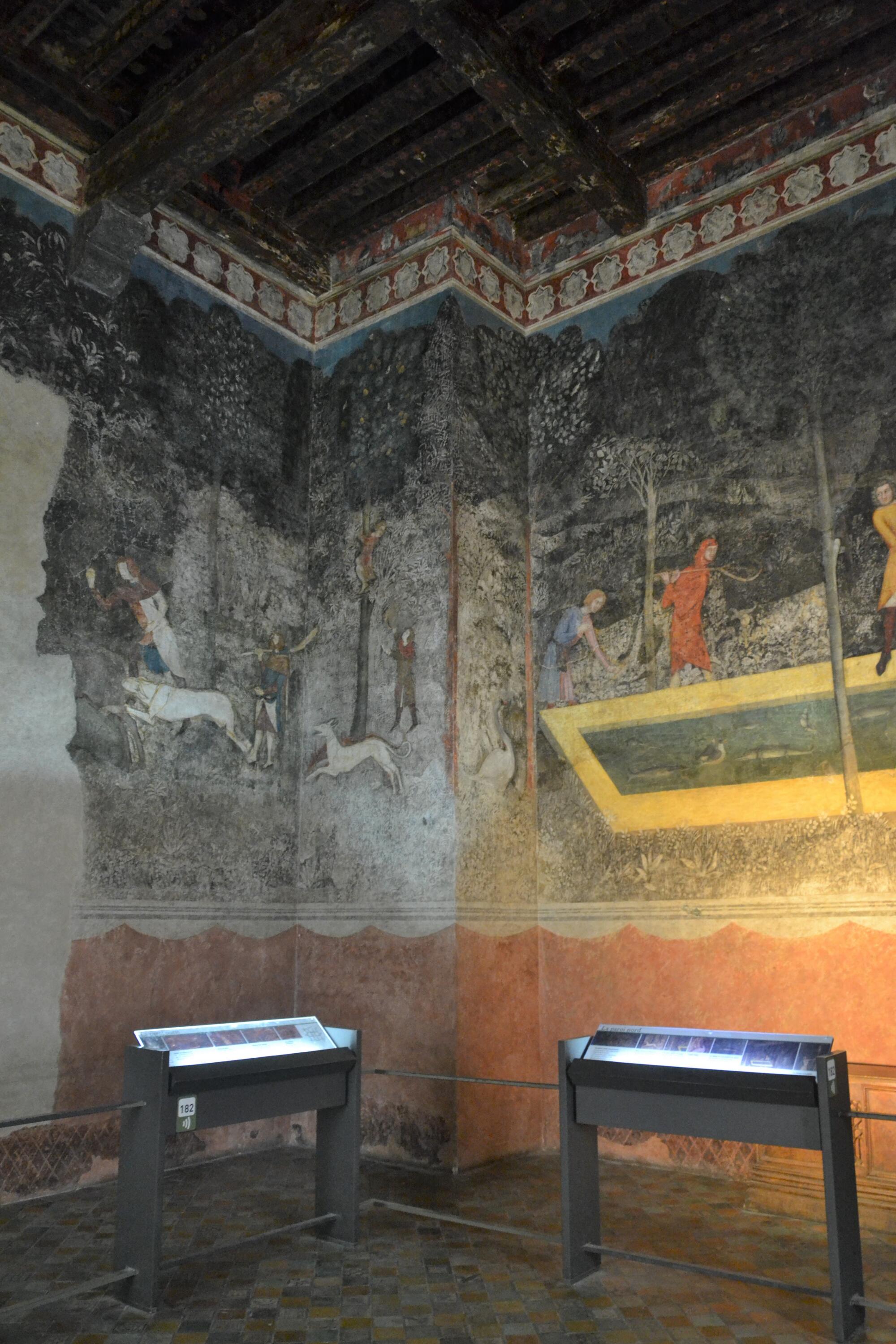 Preview of: The Chamber of the Deer murals Salle ornée de fresques murales représentant des scènes de chasse et un jardin, avec plafond à poutres apparentes.