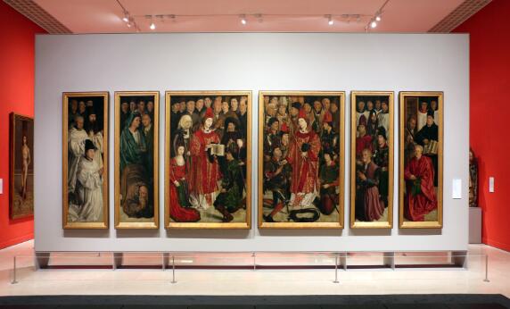 Ensemble de six panneaux peints représentant des groupes de personnages – ecclésiastiques, nobles, chevaliers et laïcs – rassemblés autour de saint Vincent vêtu des ornements liturgiques rouges, exposé dans une salle de musée.