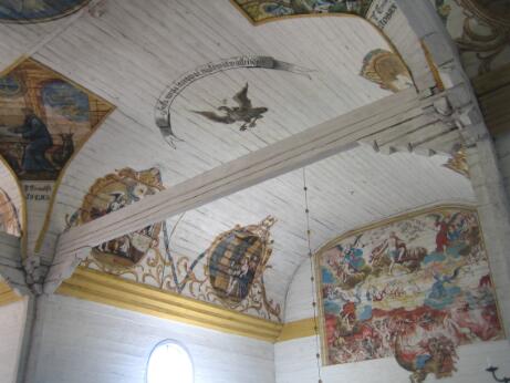 Vue intérieure d'une église en bois dont les murs et la voûte sont ornés de peintures religieuses représentant des scènes bibliques, des évangélistes et le Jugement dernier.