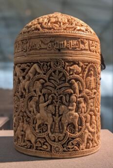 Pyxide en ivoire sculpté, ornée de scènes figurées, d'animaux et d'inscriptions arabes.
