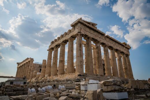 Photographie représentant les ruines d'un temple antique à colonnes sous un ciel nuageux.