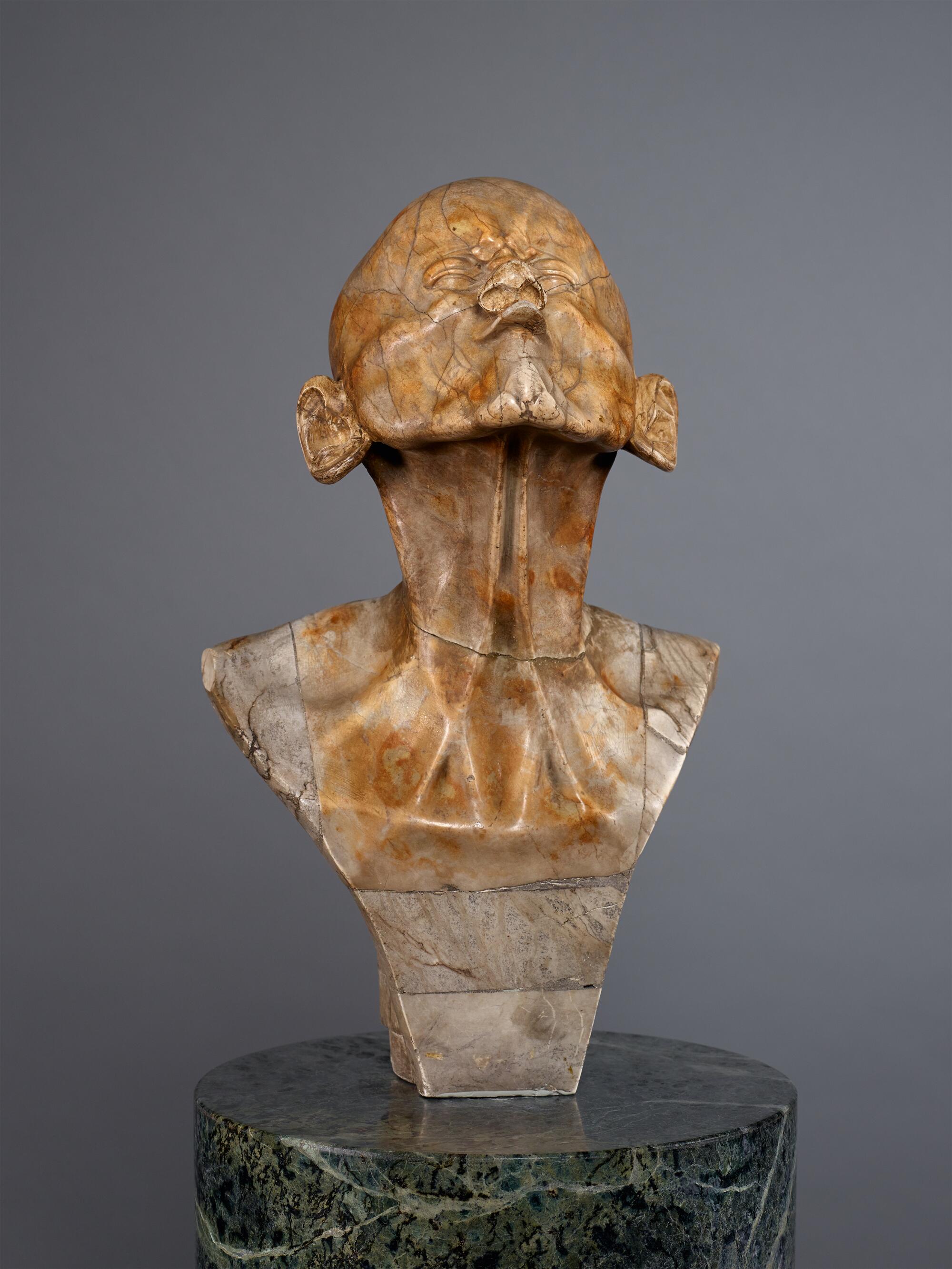 Preview of: So-called Schnabelkopf Sculpture en marbre représentant un buste masculin à la tête rejetée en arrière, aux traits volontairement déformés et au cou exagérément allongé.