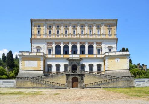 Vue de la façade monumentale d'un palais Renaissance italien, caractérisée par sa composition symétrique, son imposant escalier extérieur et son architecture classique.