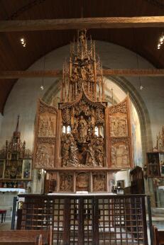 Photographie montrant un retable gothique en bois sculpté dans une église.
