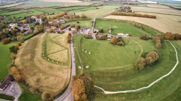 Vue aérienne d'un cercle mégalithique et de son enceinte de terre dans un paysage rural.
